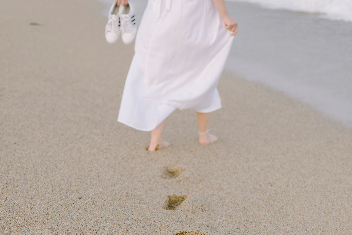Eine Dame läuft am Strand